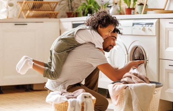 A family loading a washing machine. 