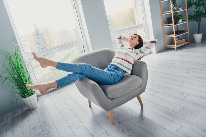 Relaxing in a chair while wearing jeans.
