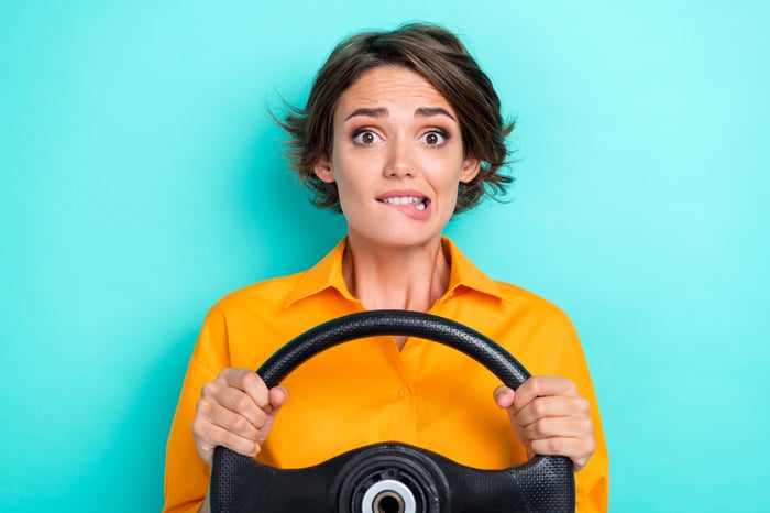 A confused person holding a steering wheel.