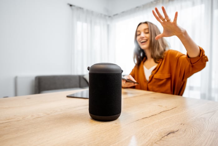 A person talks to a smart speaker.