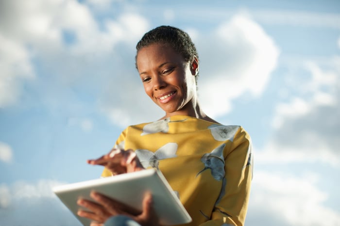 A person uses a tablet computer outdoors.