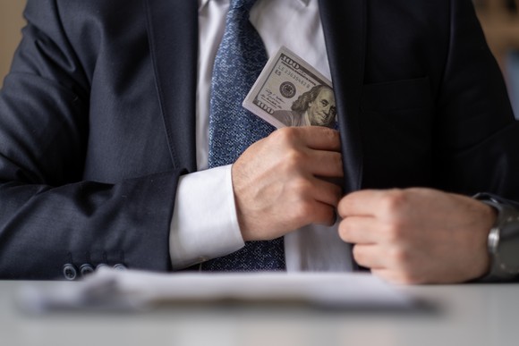 A man putting money in his pocket.