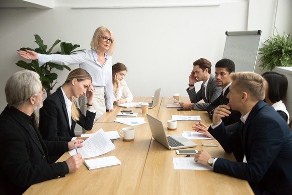 Group of people arguing in a board room.