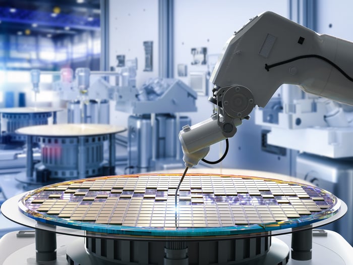 A robotic arm assembling a wafer.