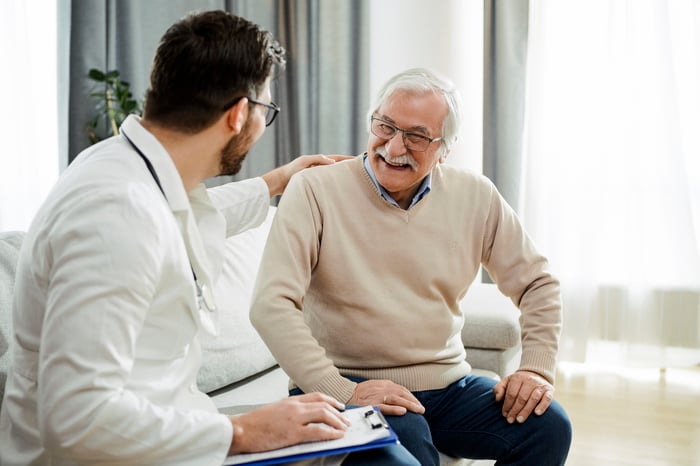 Physician talking with a smiling patient.