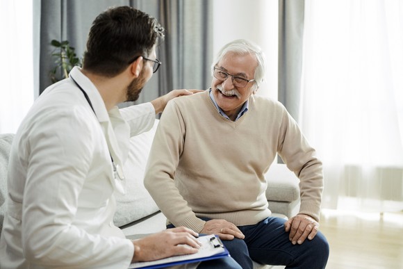 Physician talking with a smiling patient.