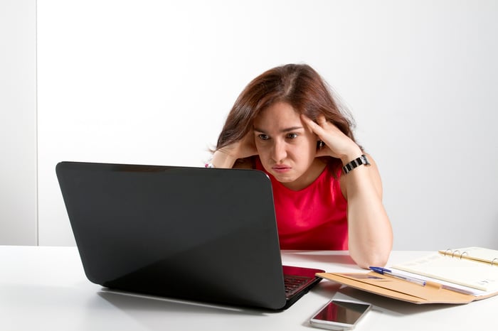 Person looking frustrated at a computer.