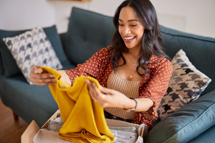 An online shopper opens a box of clothing.