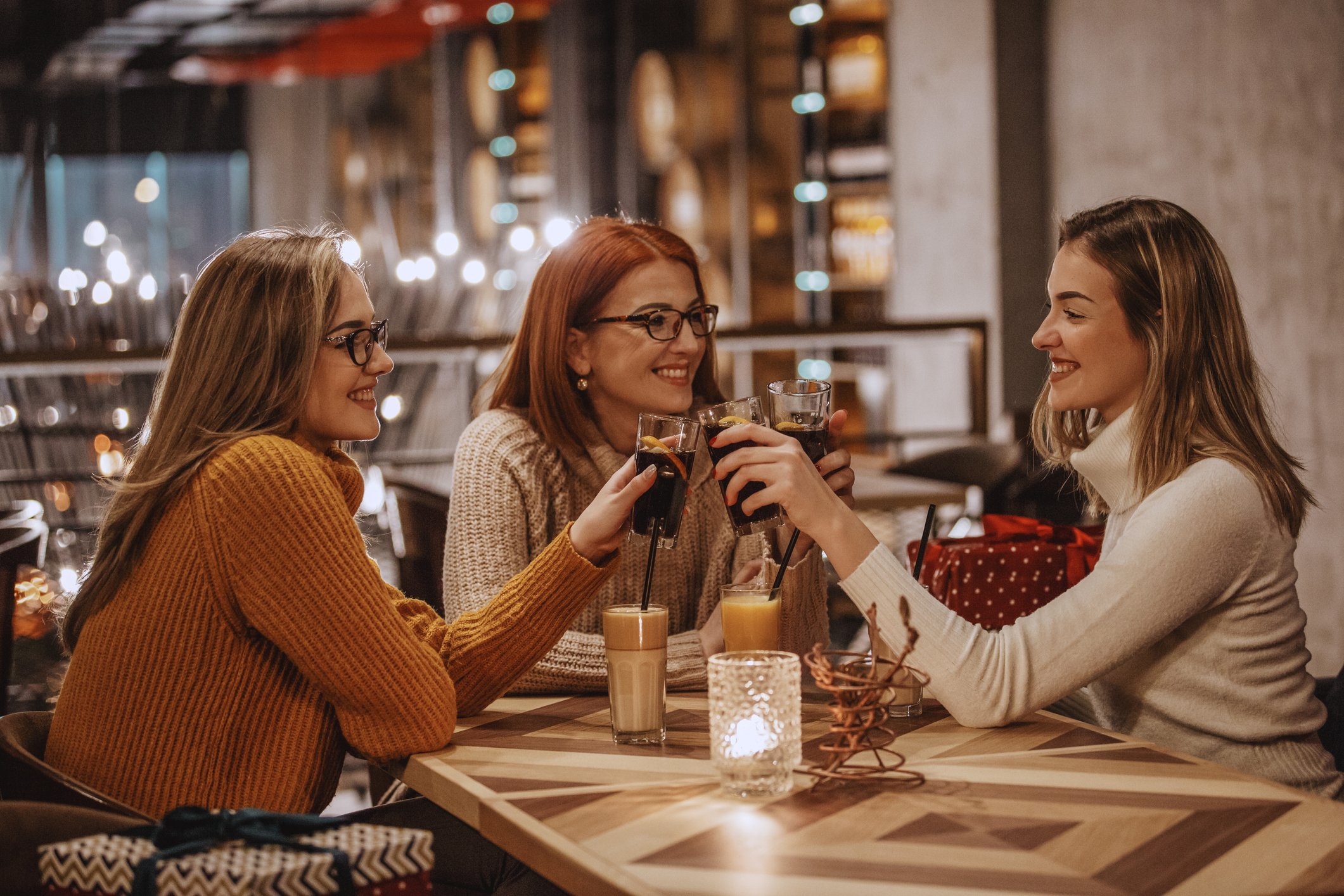 Three people drinking cola at a restaurant.