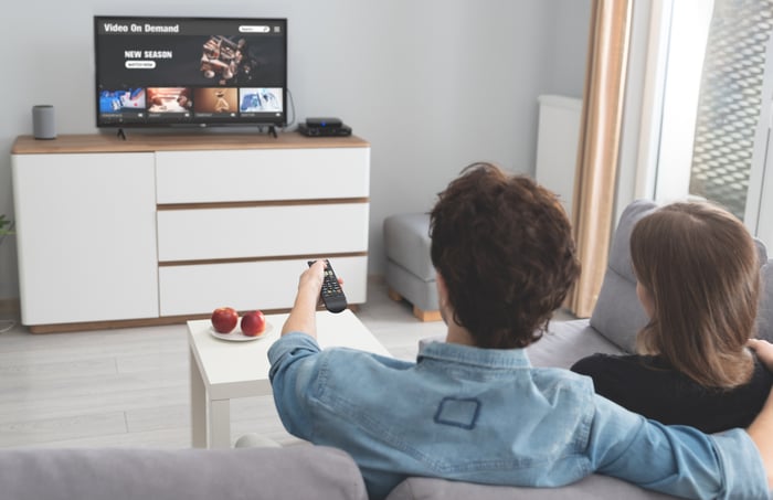 A couple streaming TV in a living room.