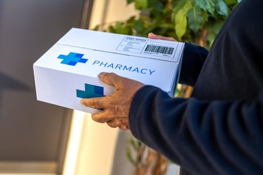 A person holding a pharmacy delivery.