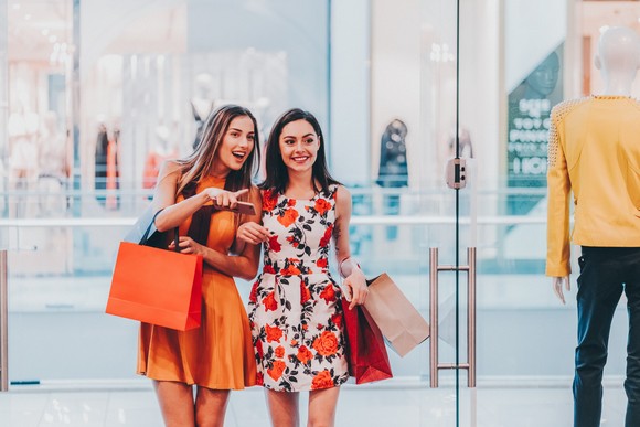 Two shoppers with bags in a department store. 
