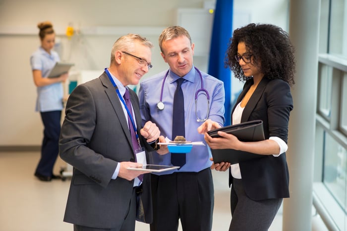 Doctor discussing a report with people.
