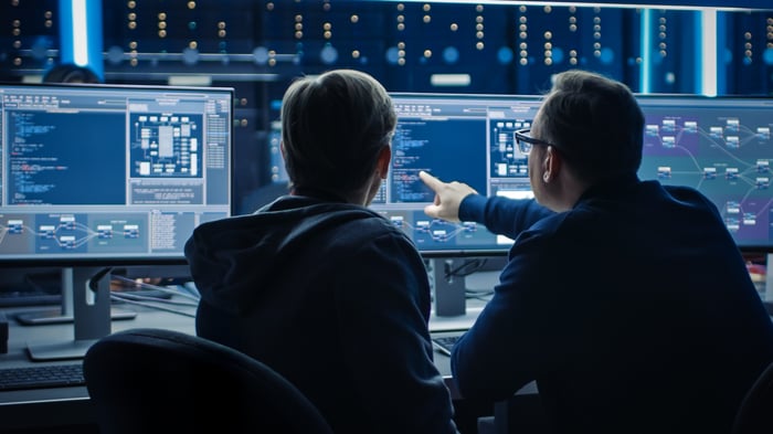 Two engineers looking at information on a computer screen.