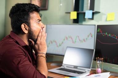 surprised investors looks at financial charts.