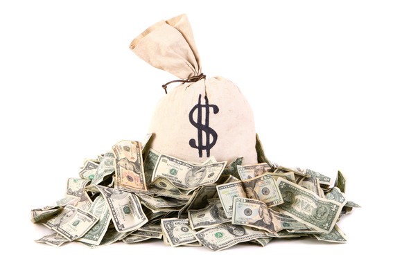 A bag of cash sitting in a pile of more cash.