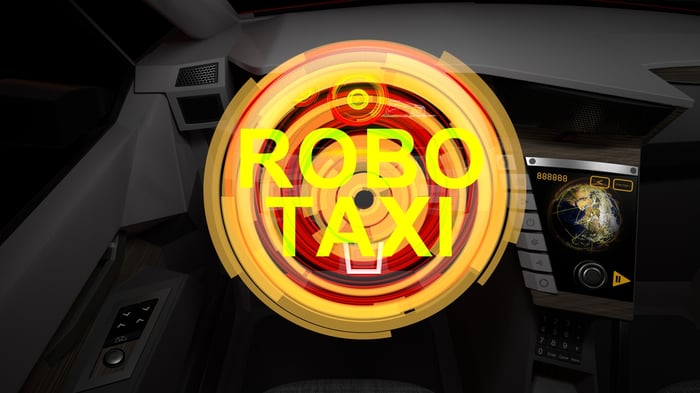 The word robotaxi illuminated inside a car.