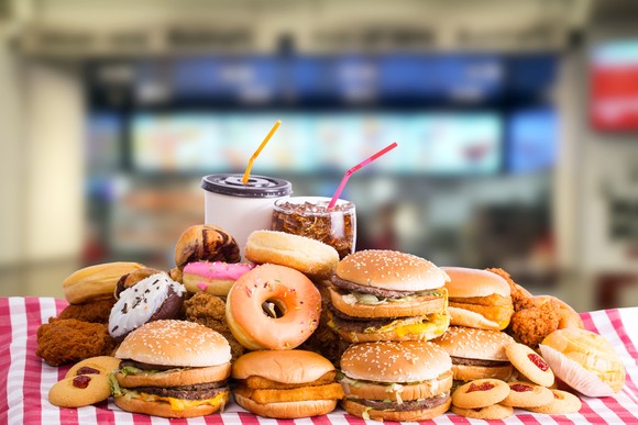 A table full of burgers and donuts.