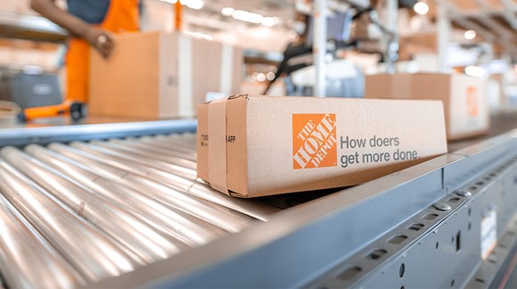 A Home Depot box at a fulfillment center moving down a ramp. 