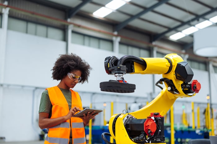 A person working in a warehouse with robots.