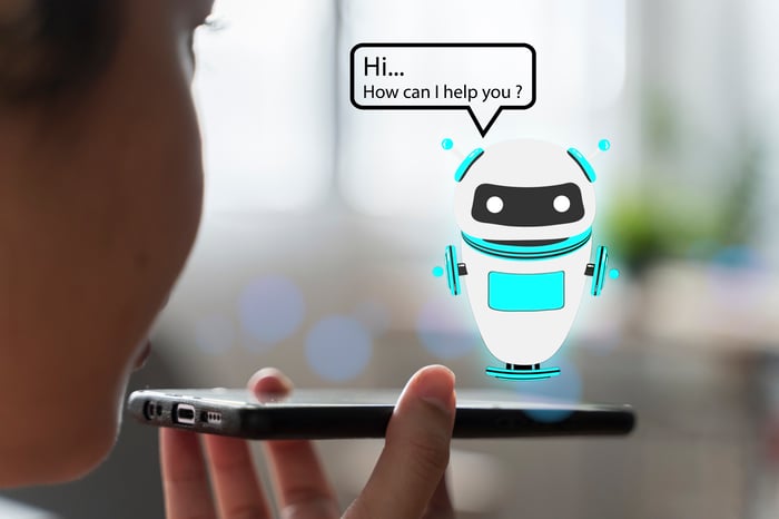 Person holding phone with robot icon hovering over it, offering help.