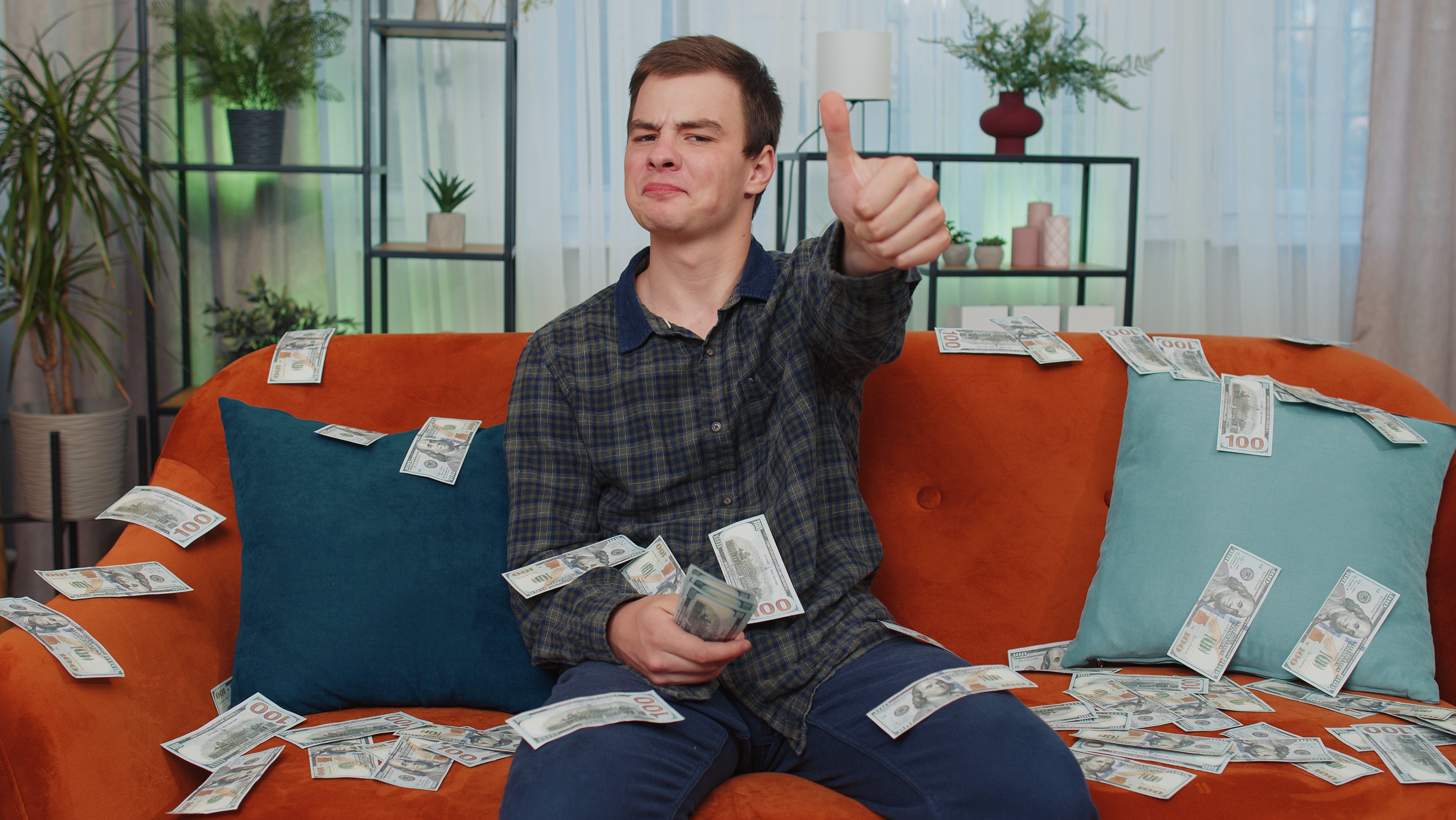 A person on a couch with money falling all around them.