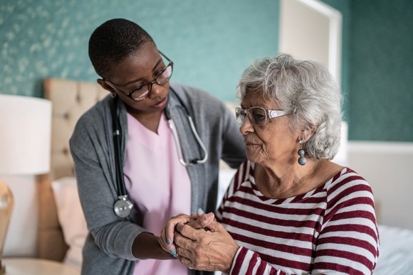 A doctor holding a patient's hands.