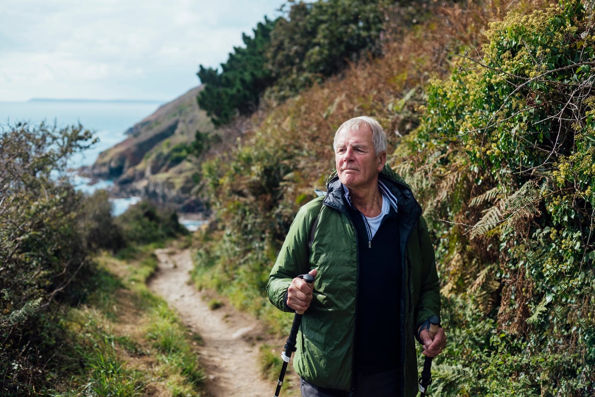 Person hiking on trail by a body of water