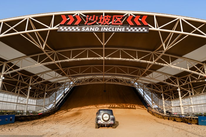 SUV going up sand dune on BYD's race track.