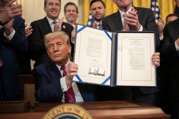 President Donald J. Trump holds a signed document.