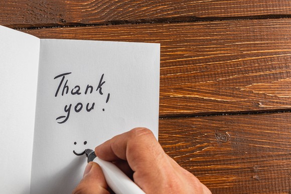 A person writing a thank-you card. 