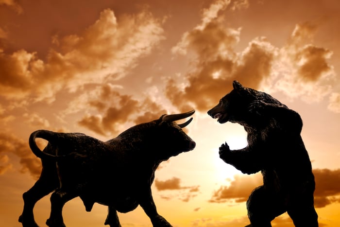 Shadows of a bull and a bear facing off in a golden sunset.