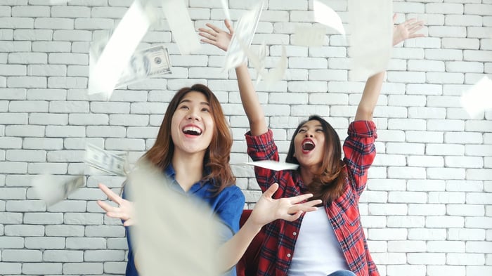 People excited throwing money up.