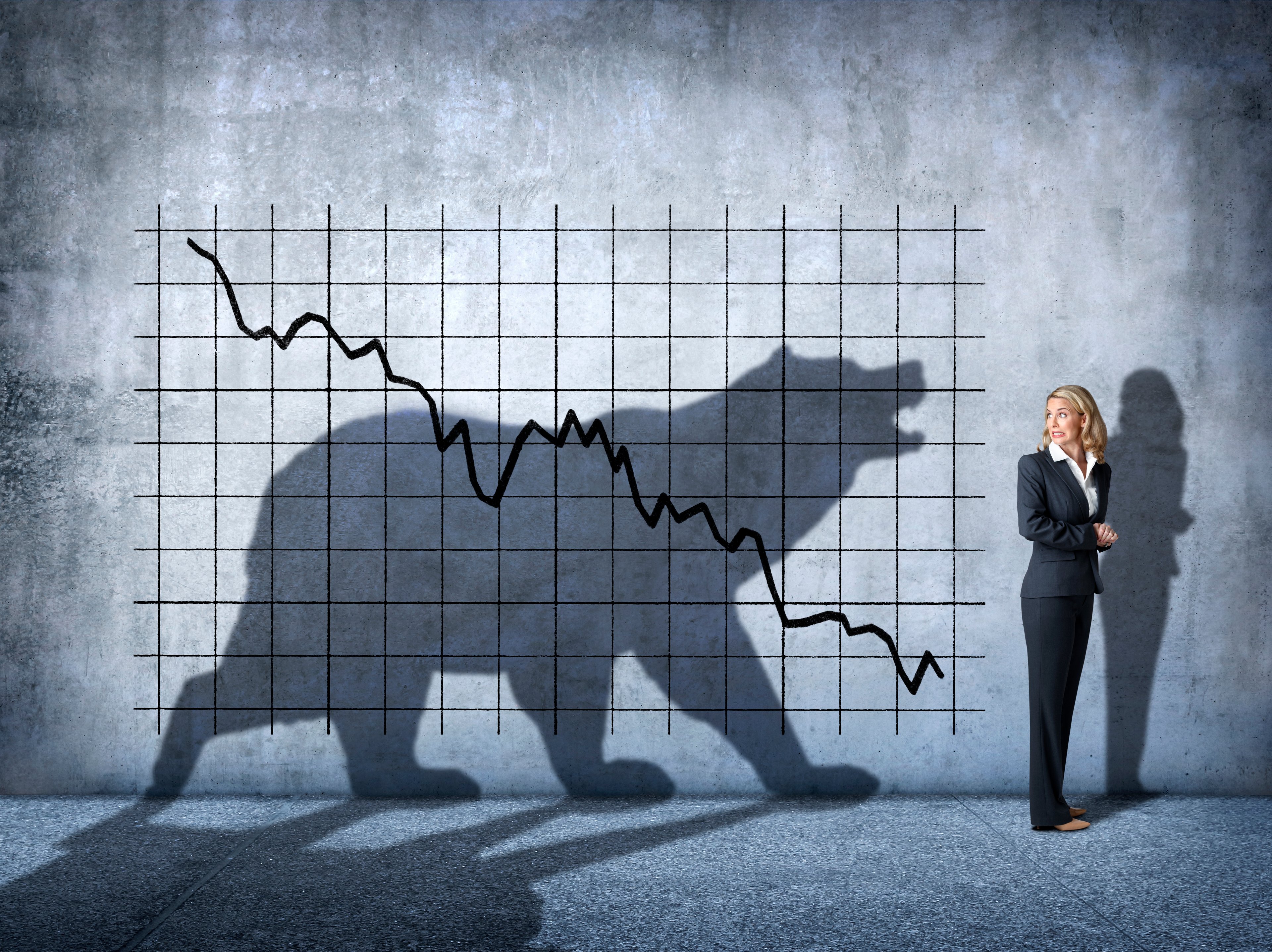 A falling stock chart with a woman looking back at it and a bear shape in the shadows. 