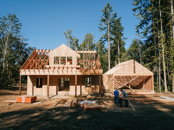 New home under construction in woodsy setting.