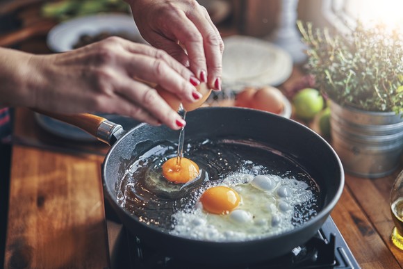 Person frying eggs.