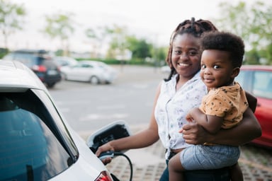 parent and child charge an electric vehicle.
