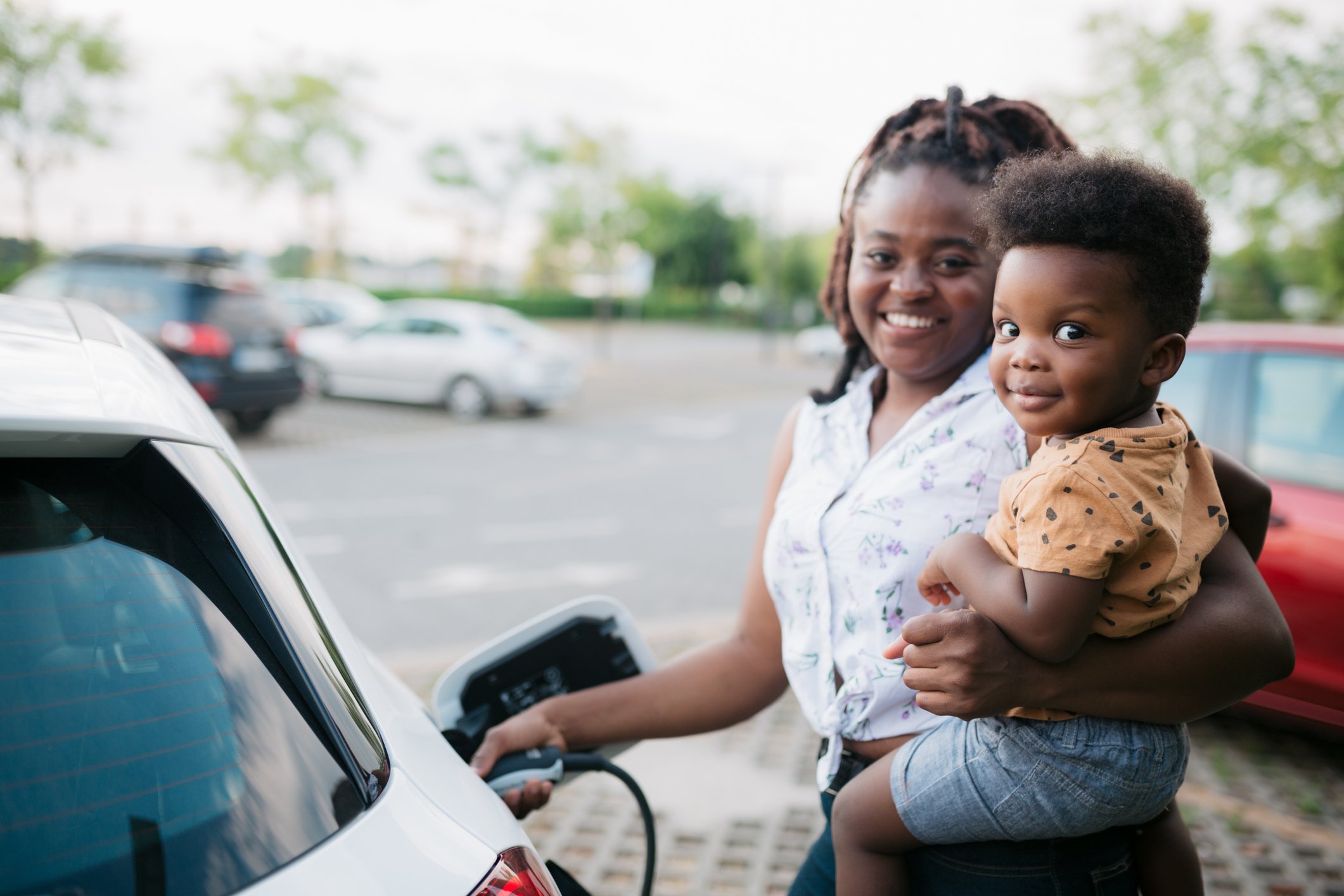 parent and child charge an electric vehicle.