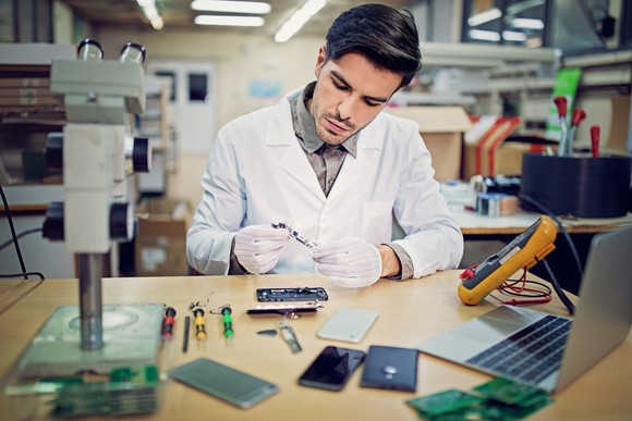 Someone working on a computer with tools.