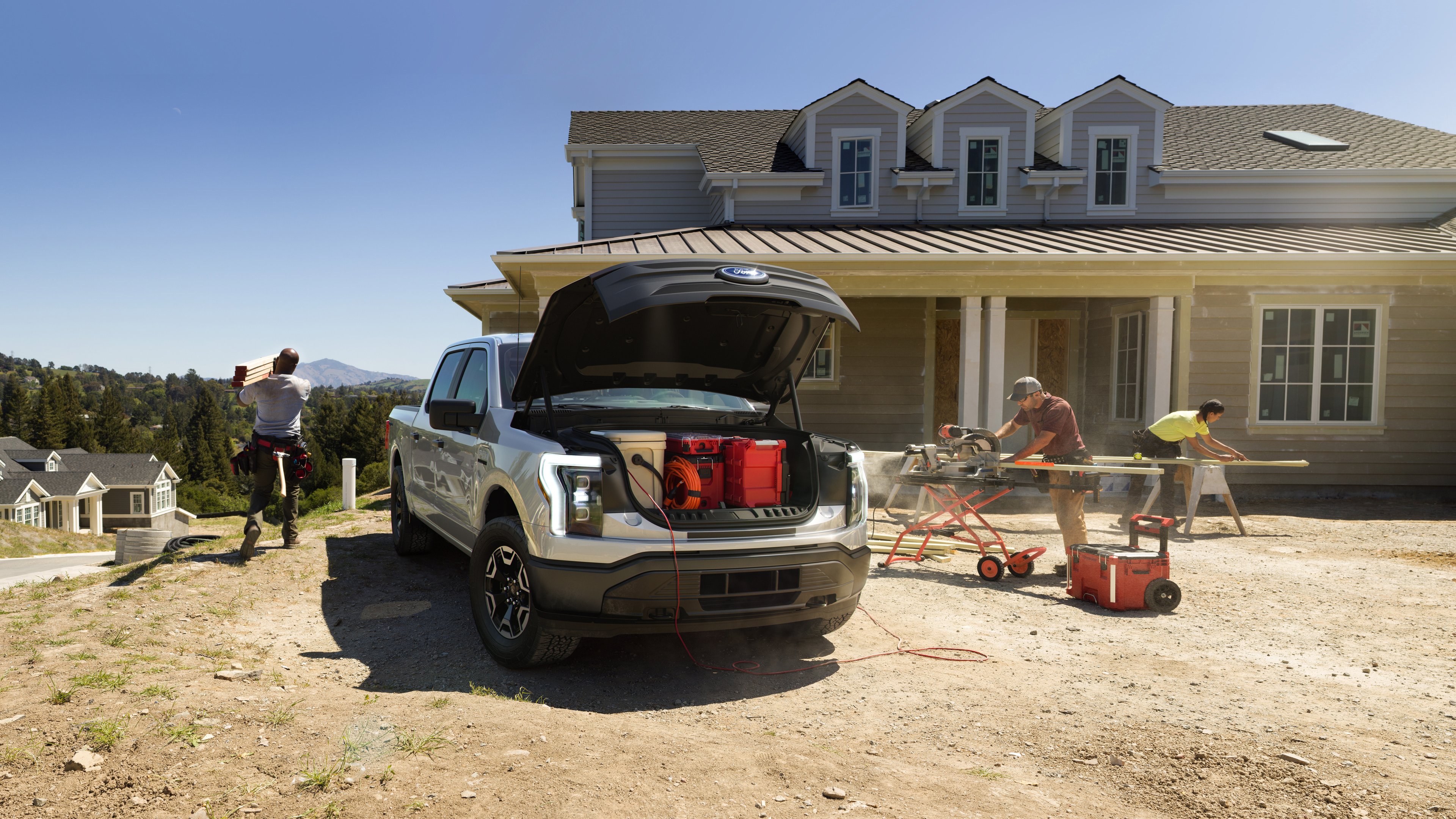 A Ford vehicle at a home construction site where people are working.