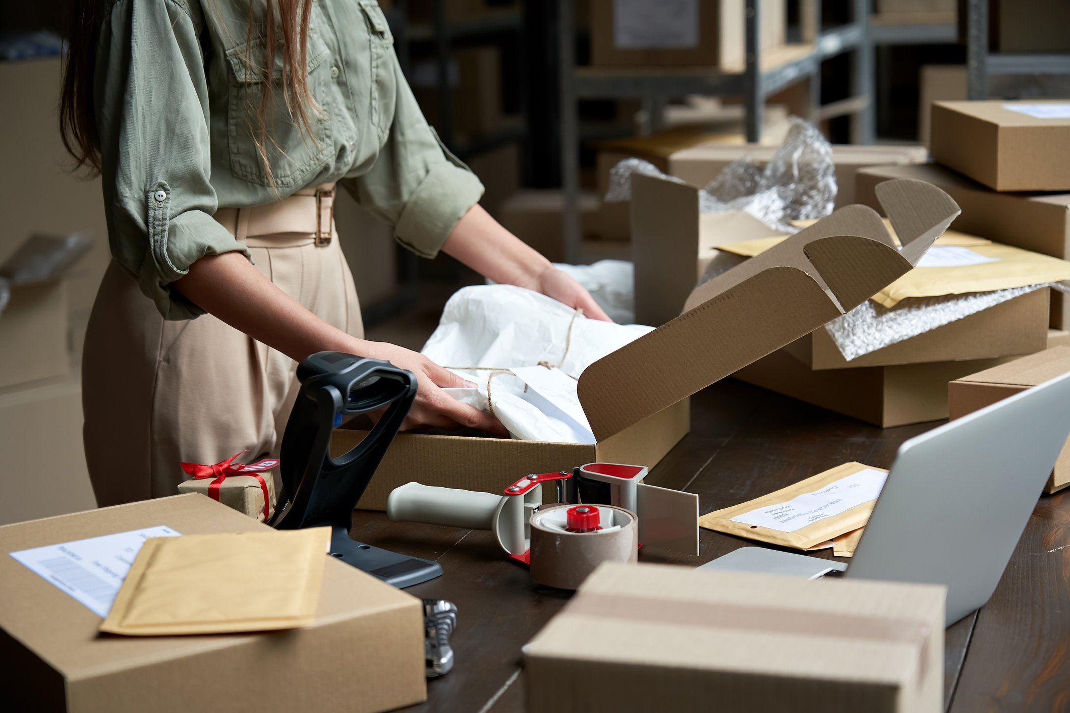 A person packs merchandise for shipping.