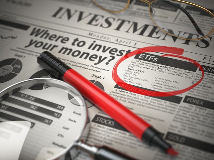 Newsprint covered with investing advice has a red circle around the word "ETFs."
