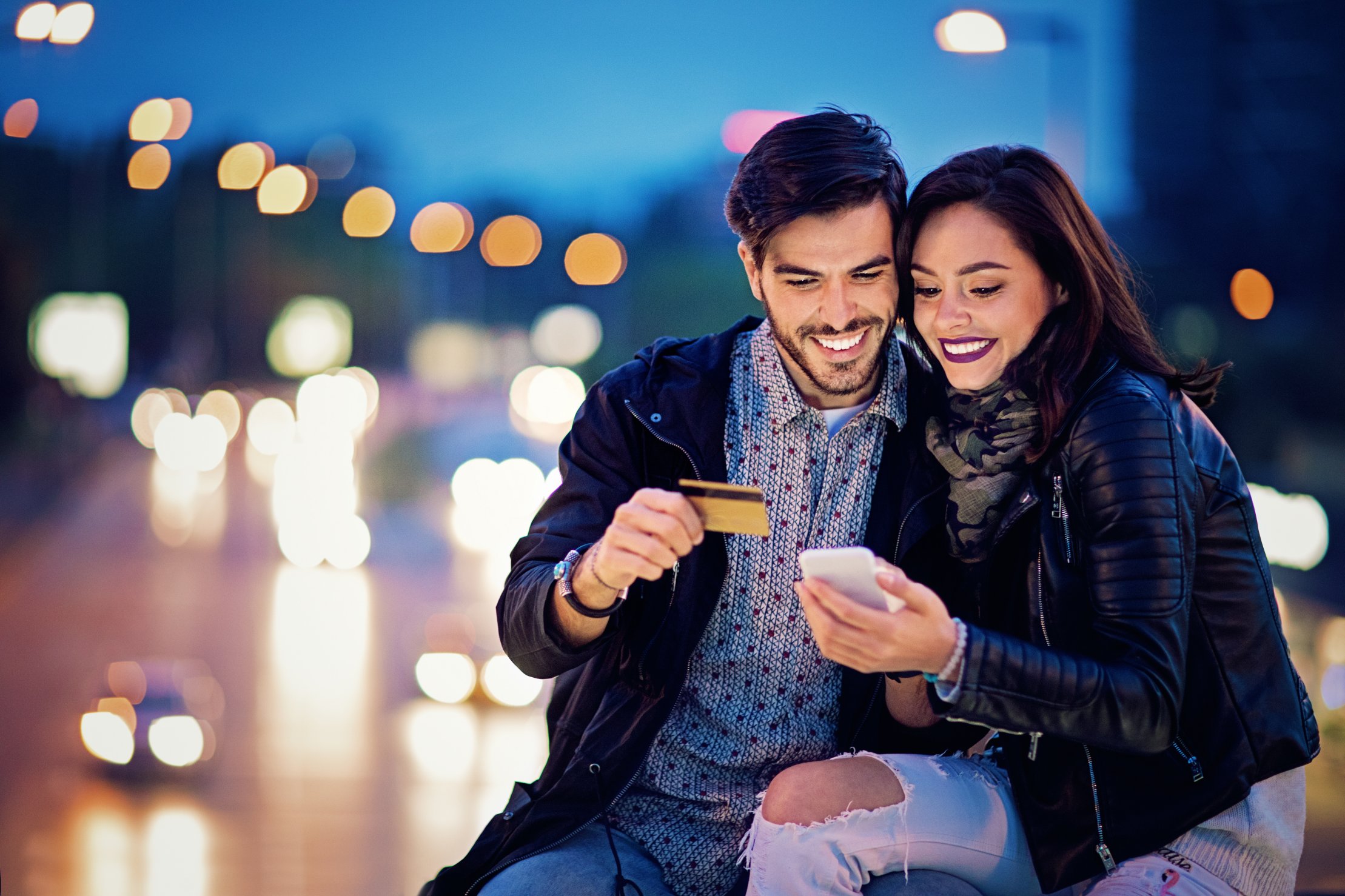 A couple uses a credit card on a smartphone. app.