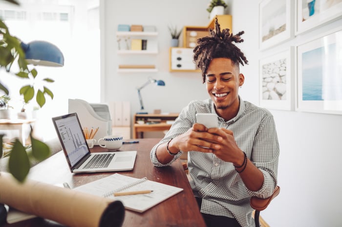 Person sitting at desk on phone.