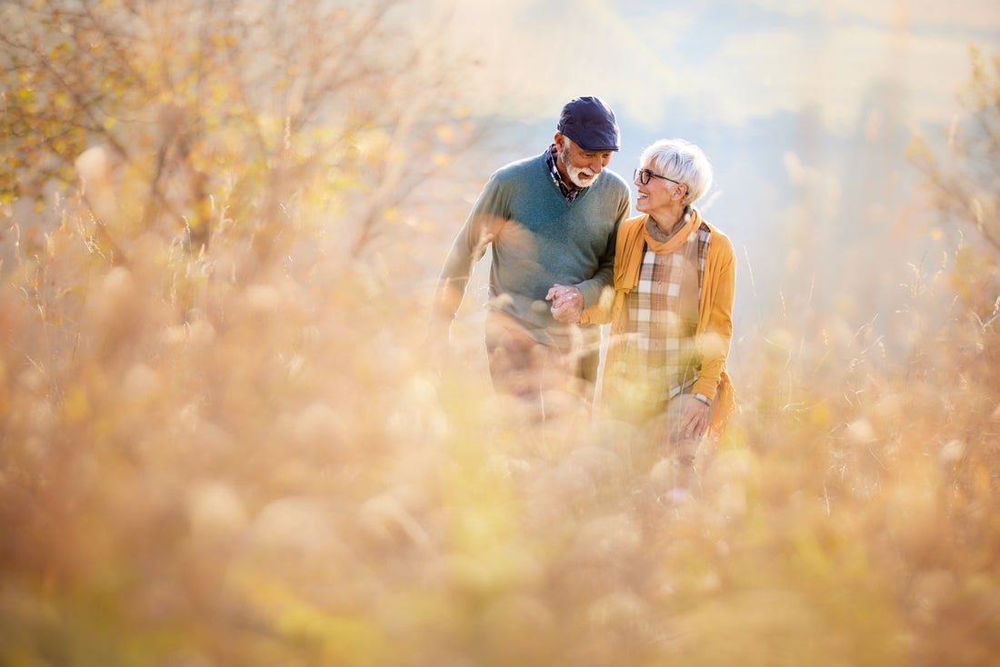 Two people strolling through a field. 