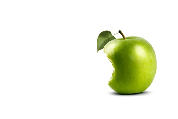 A green apple with a large bite taken out of it.