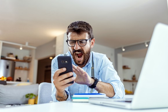 Person shouting at a smartphone.