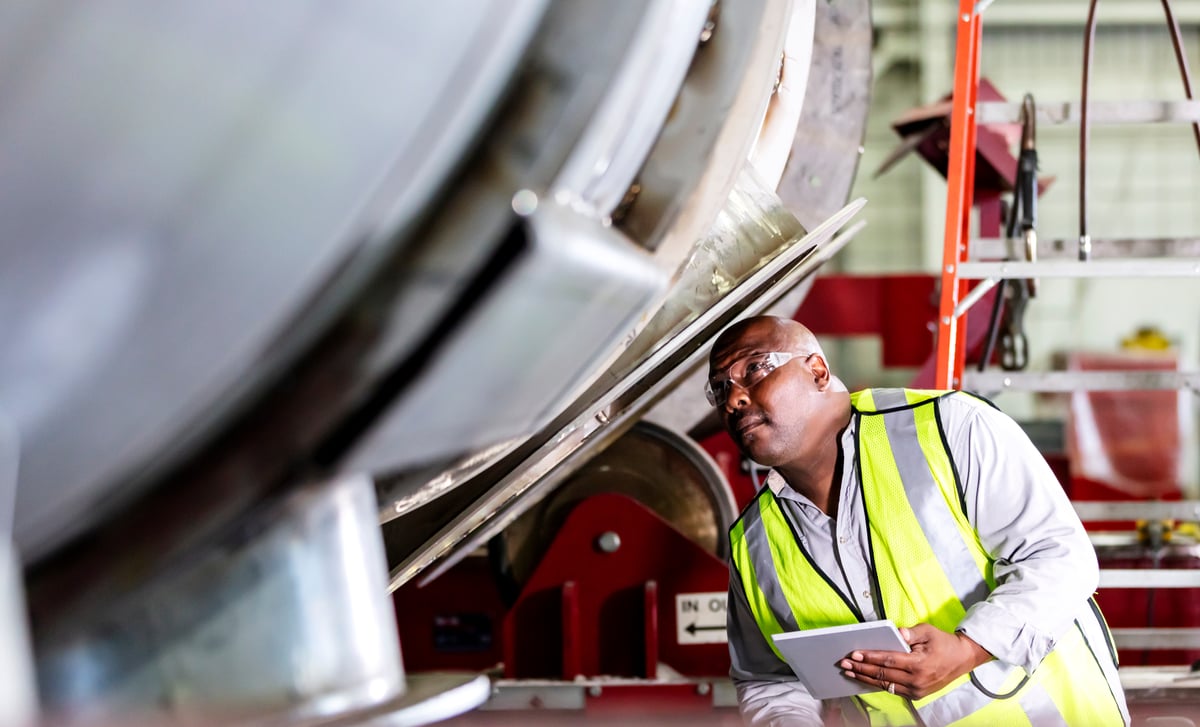 A worker inspects industrial equipment. 