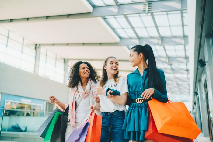 Three people shopping in a mall.