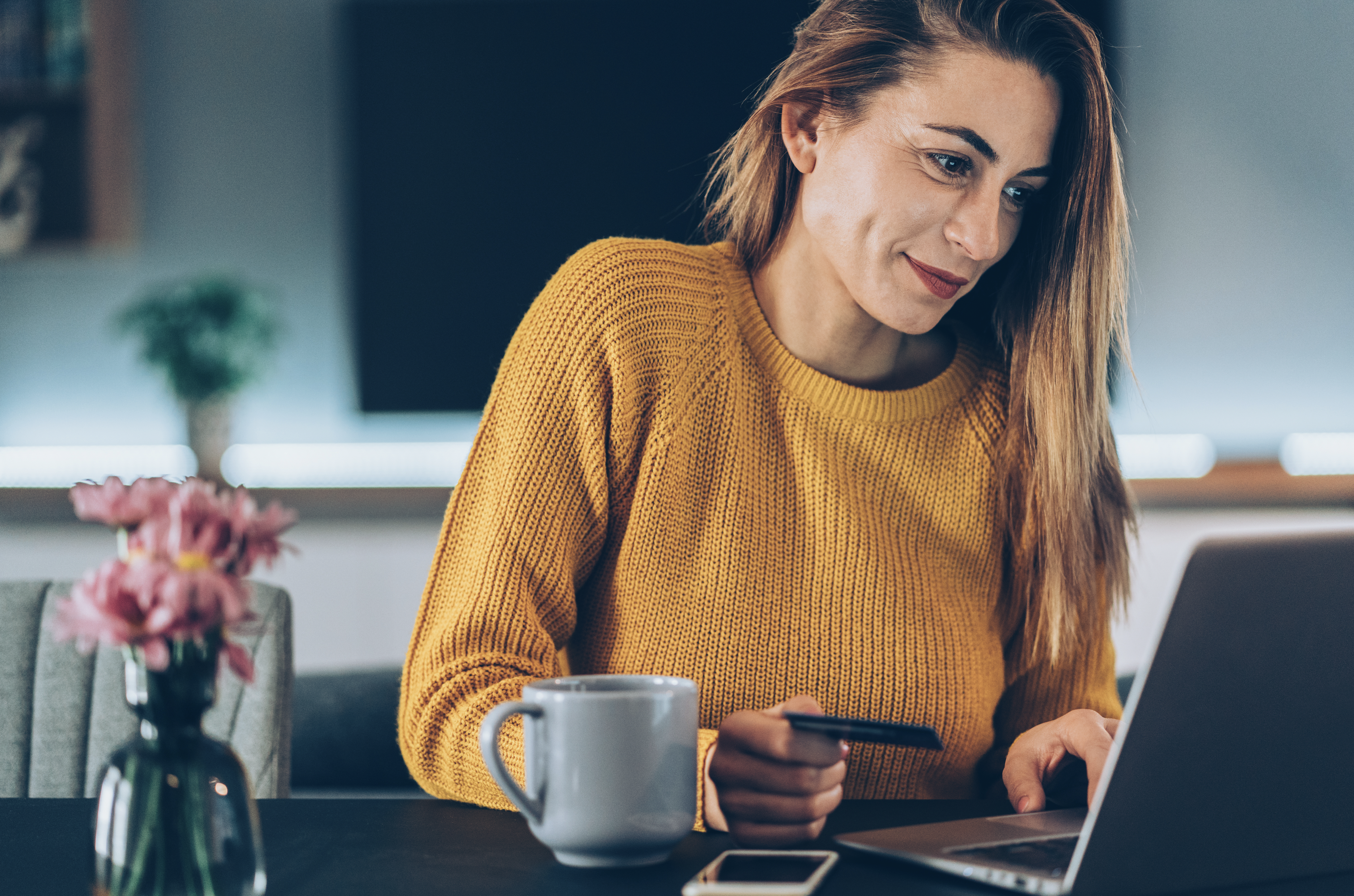 A person holding a credit card while shopping online.
